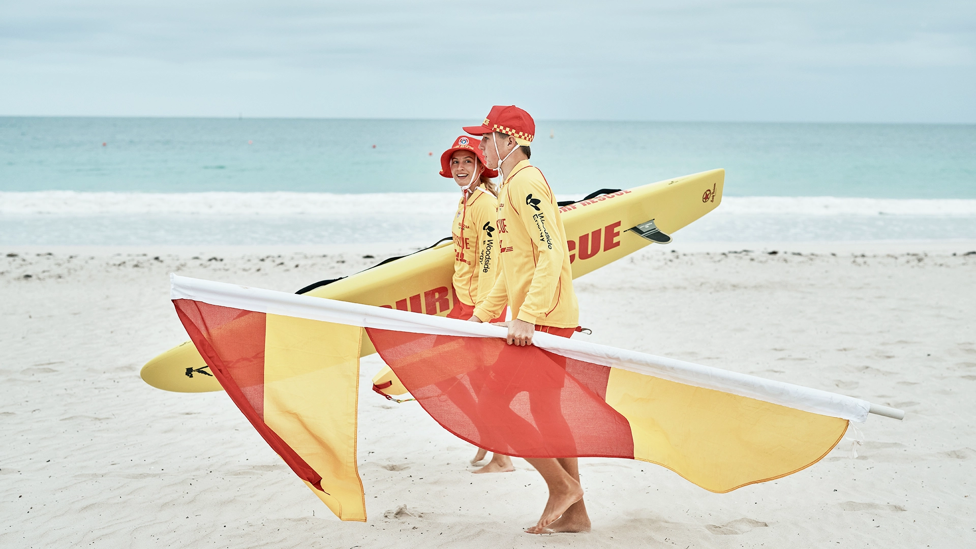 Surf lifesavers setting up the patrol flags on the sand