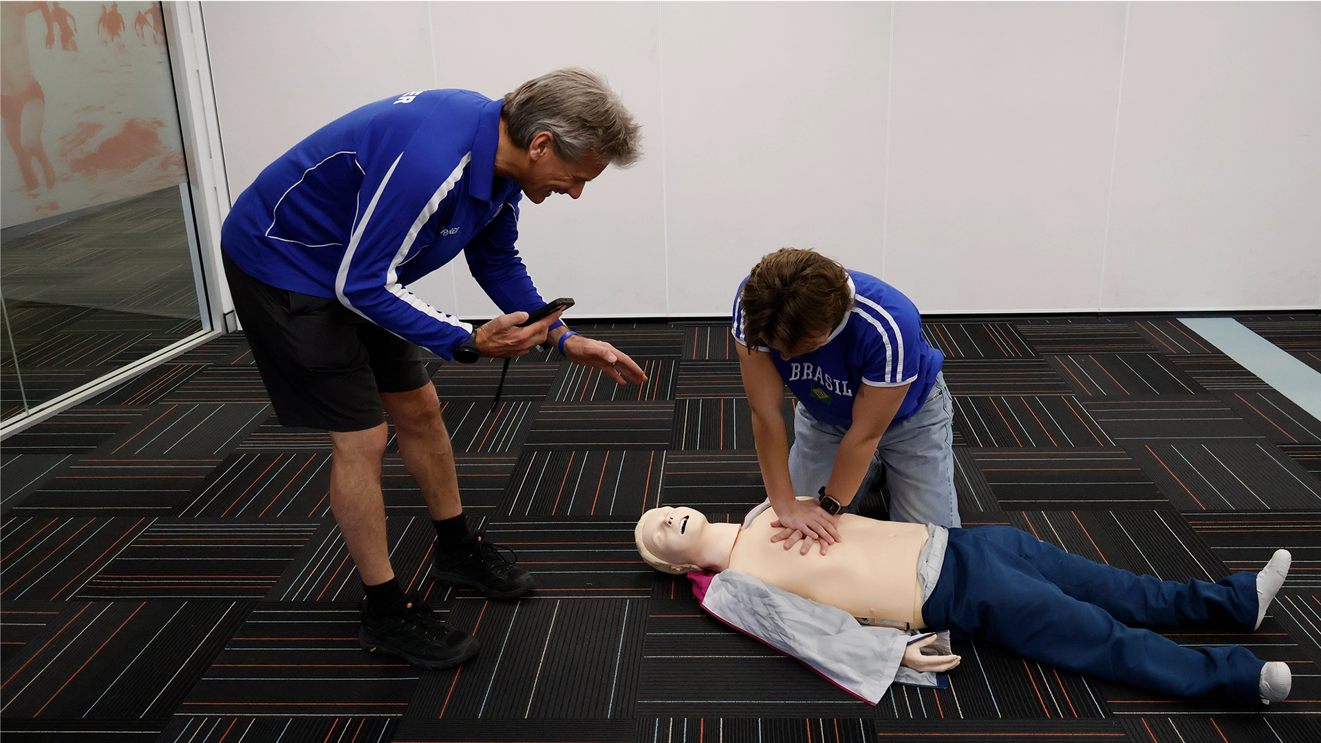 A trainer demonstrating CPR on a manikin