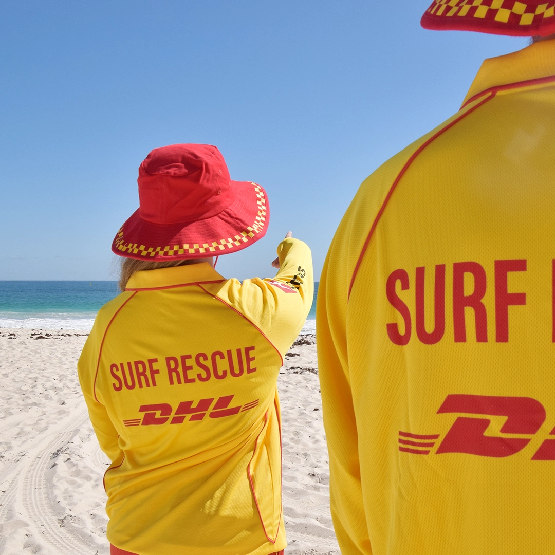 Two surf lifesavers in Surf Rescue uniforms looking out to sea