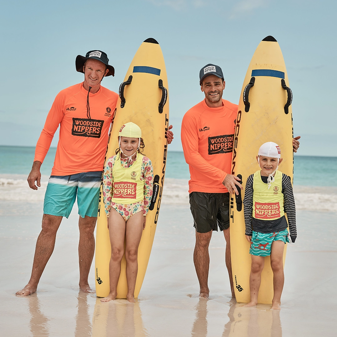 Adults and children with nipper boards during a water safety session