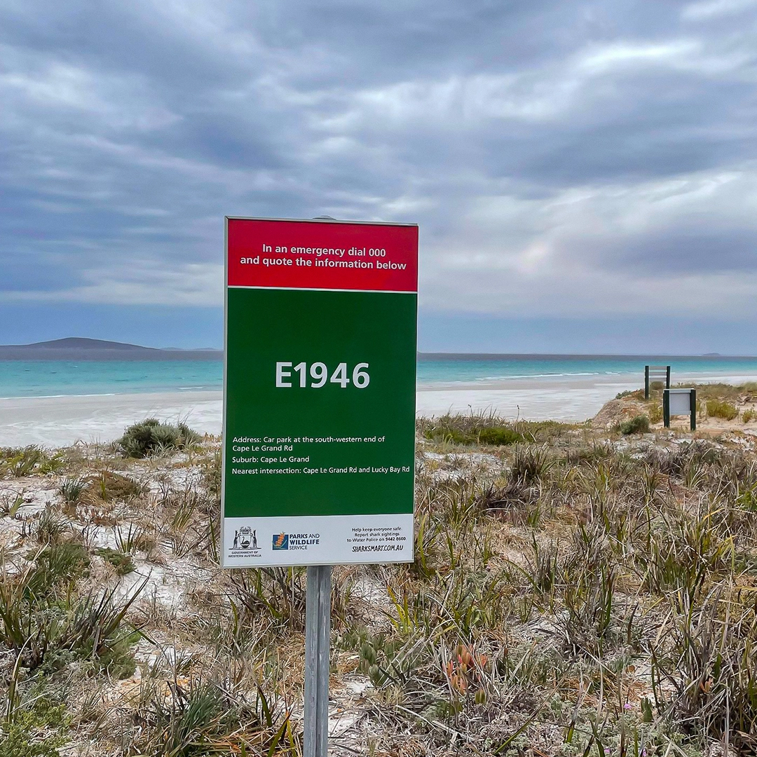 A Beach Emergency Number sign, E1946, on a coastal path