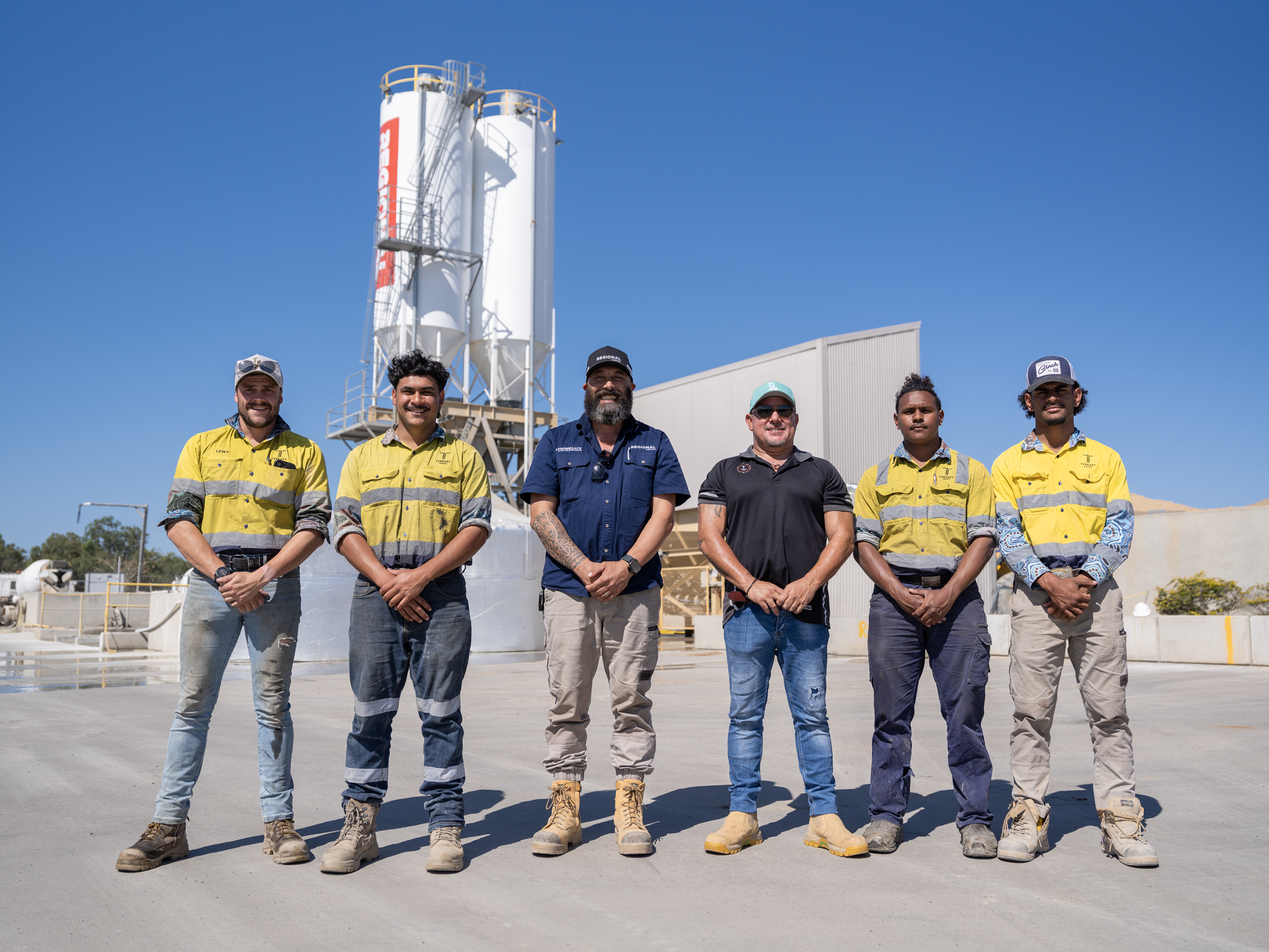 Team members standing together at a concrete plant overlay.
