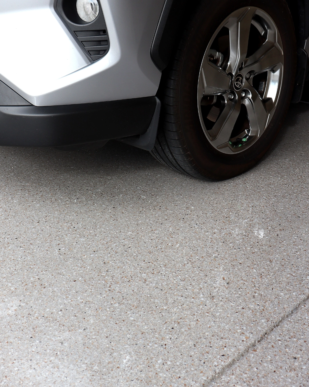 Small SUV parked on a flake epoxy floor