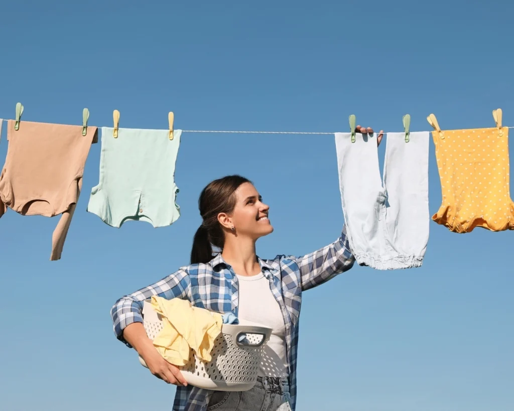 A lady removing washing from a clothesline
