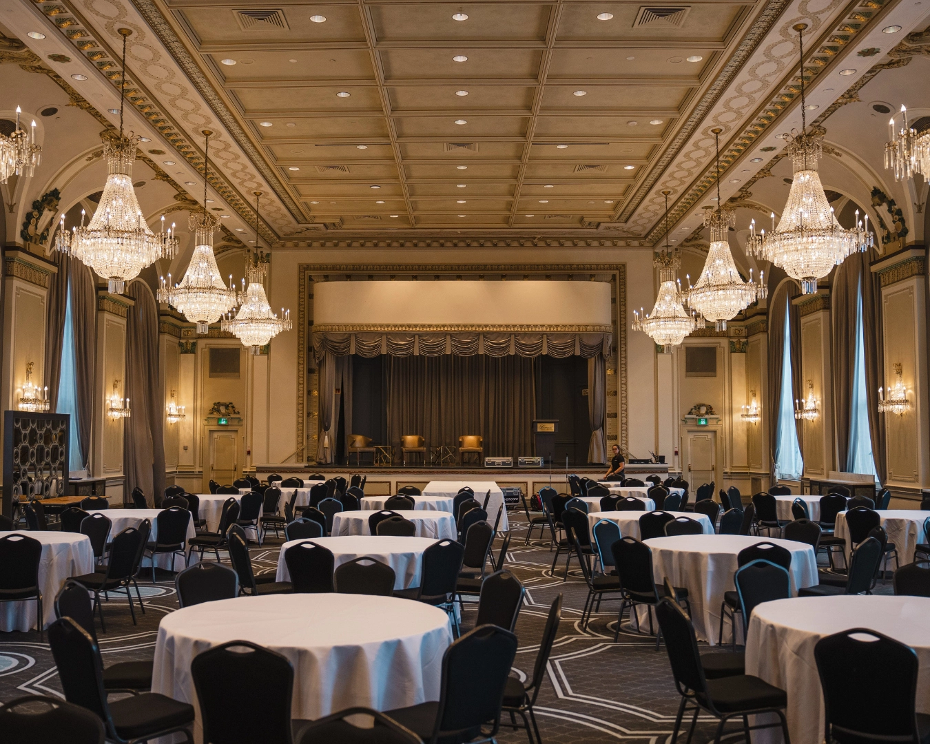 Ornate function space with many tables and chairs