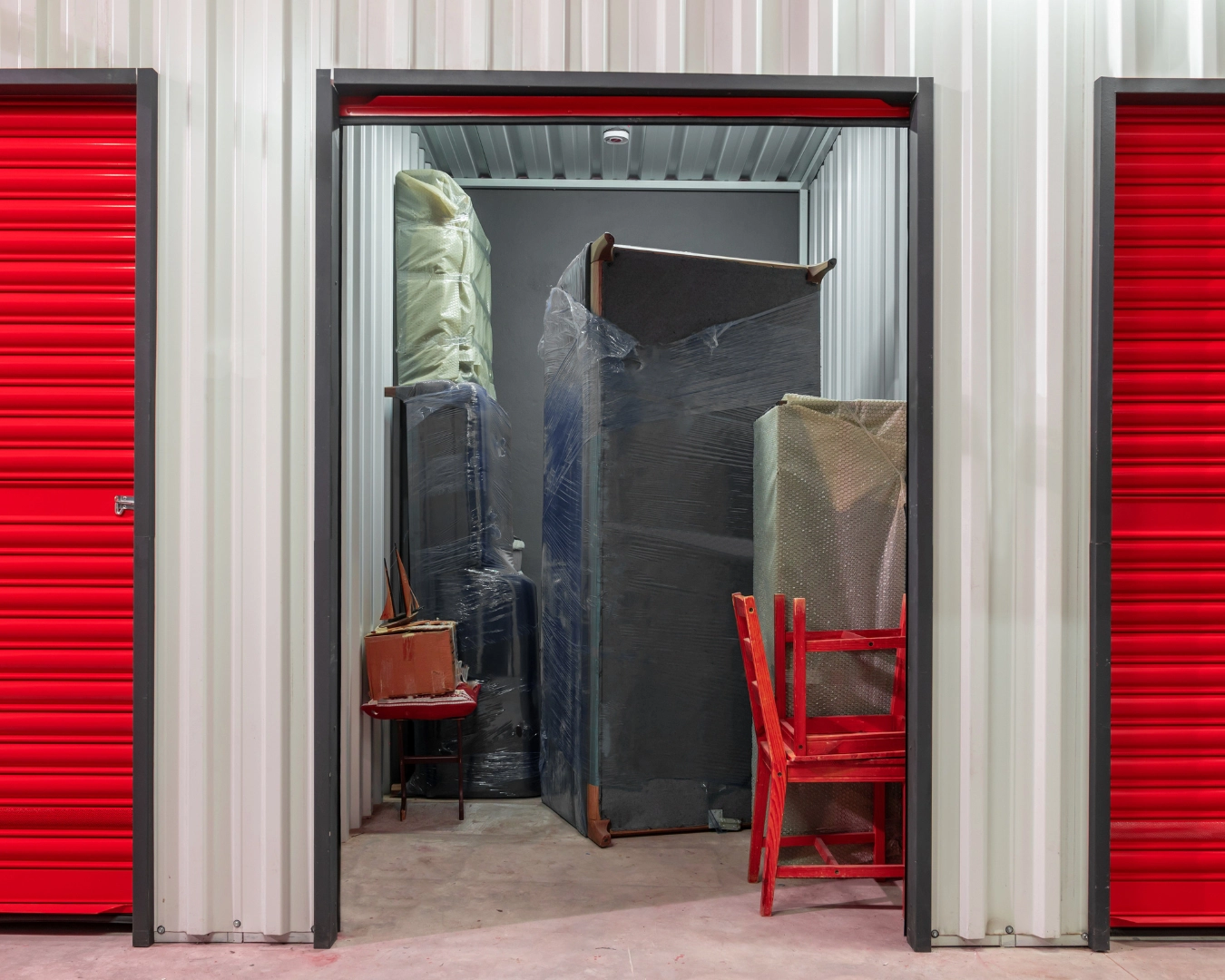 Self storage unit with door open and various furniture inside