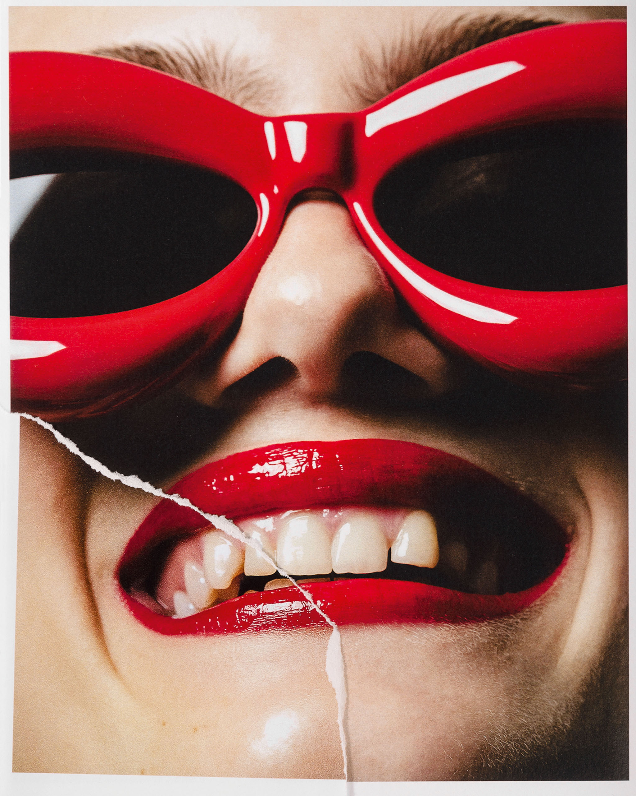 A woman wearing red lipstick and red sunglasses