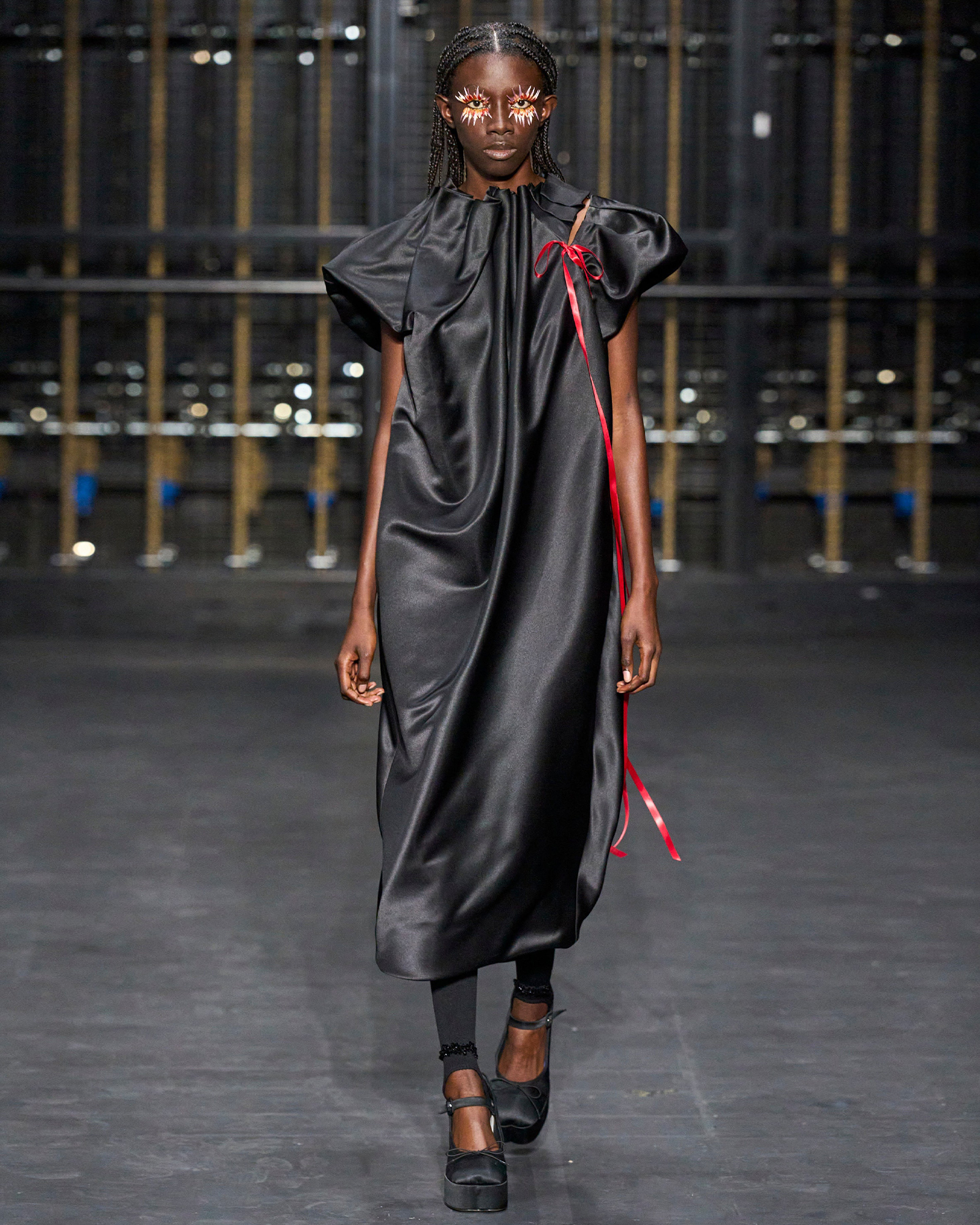 Black dress with red ribbon detail by Simone Rocha.