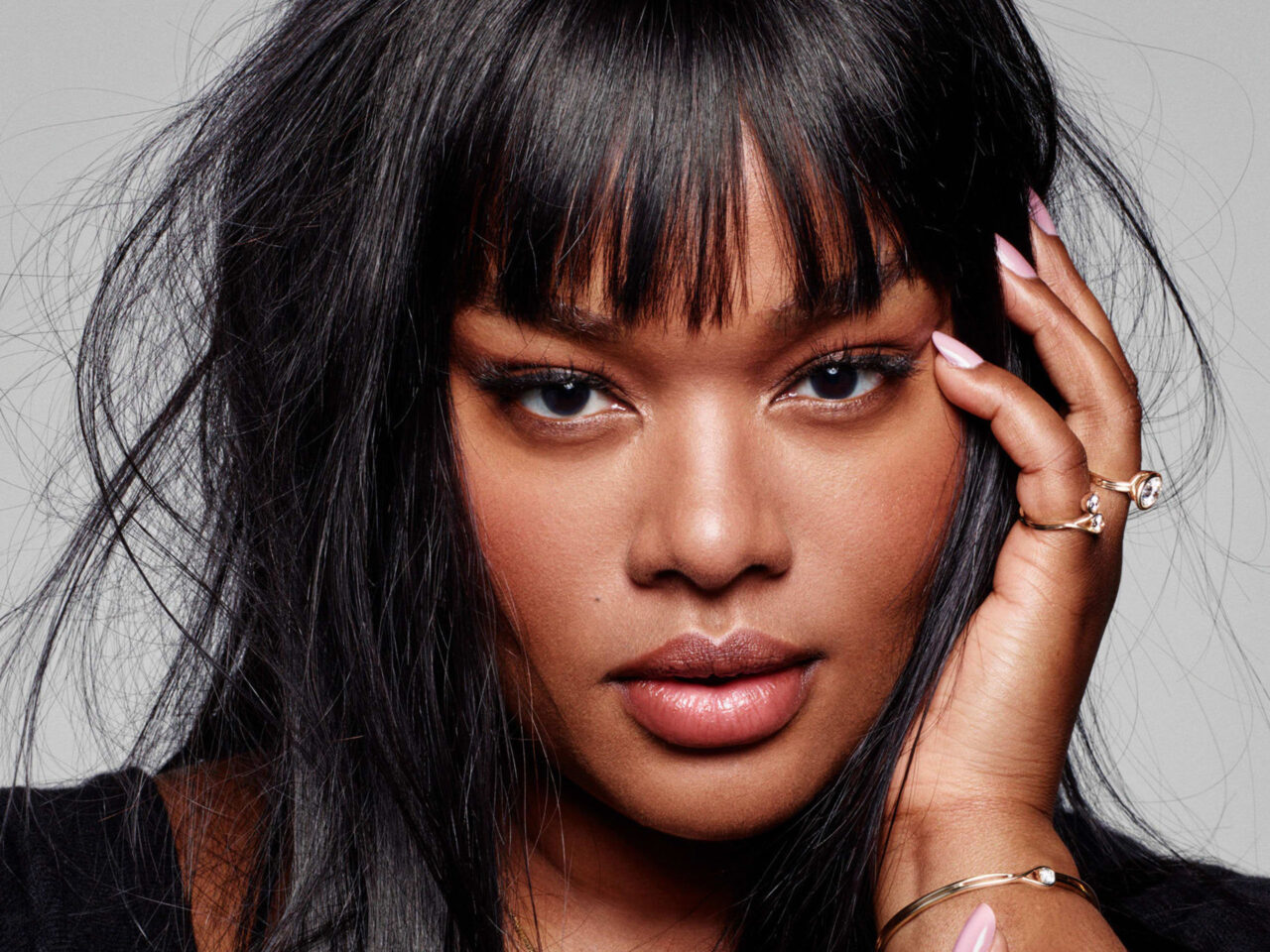 Portrait of a woman with blonde hair smiling wearing pandora rings and bracelets as jewelry