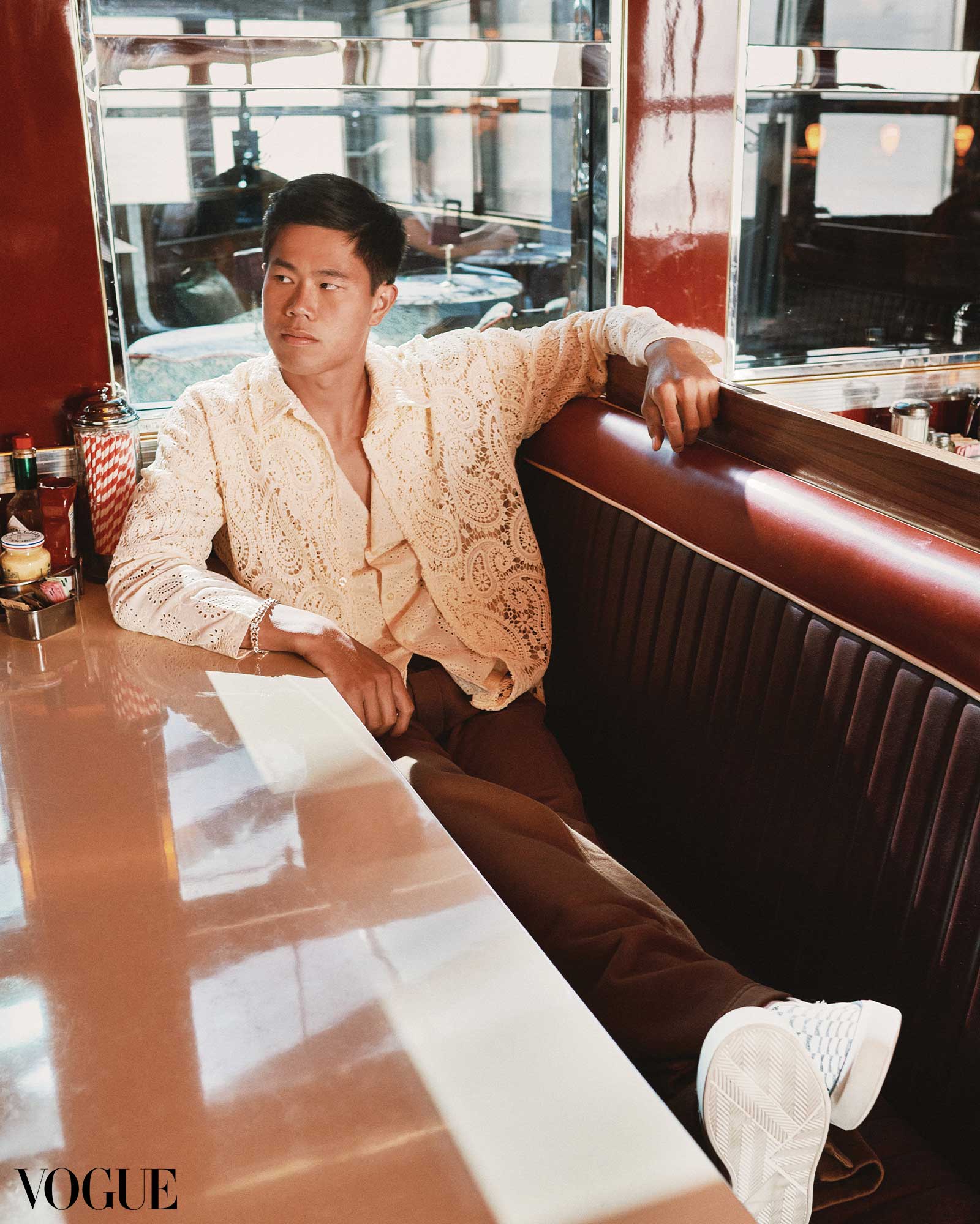 EJ Obiena sits at a diner booth Vogue Philippines