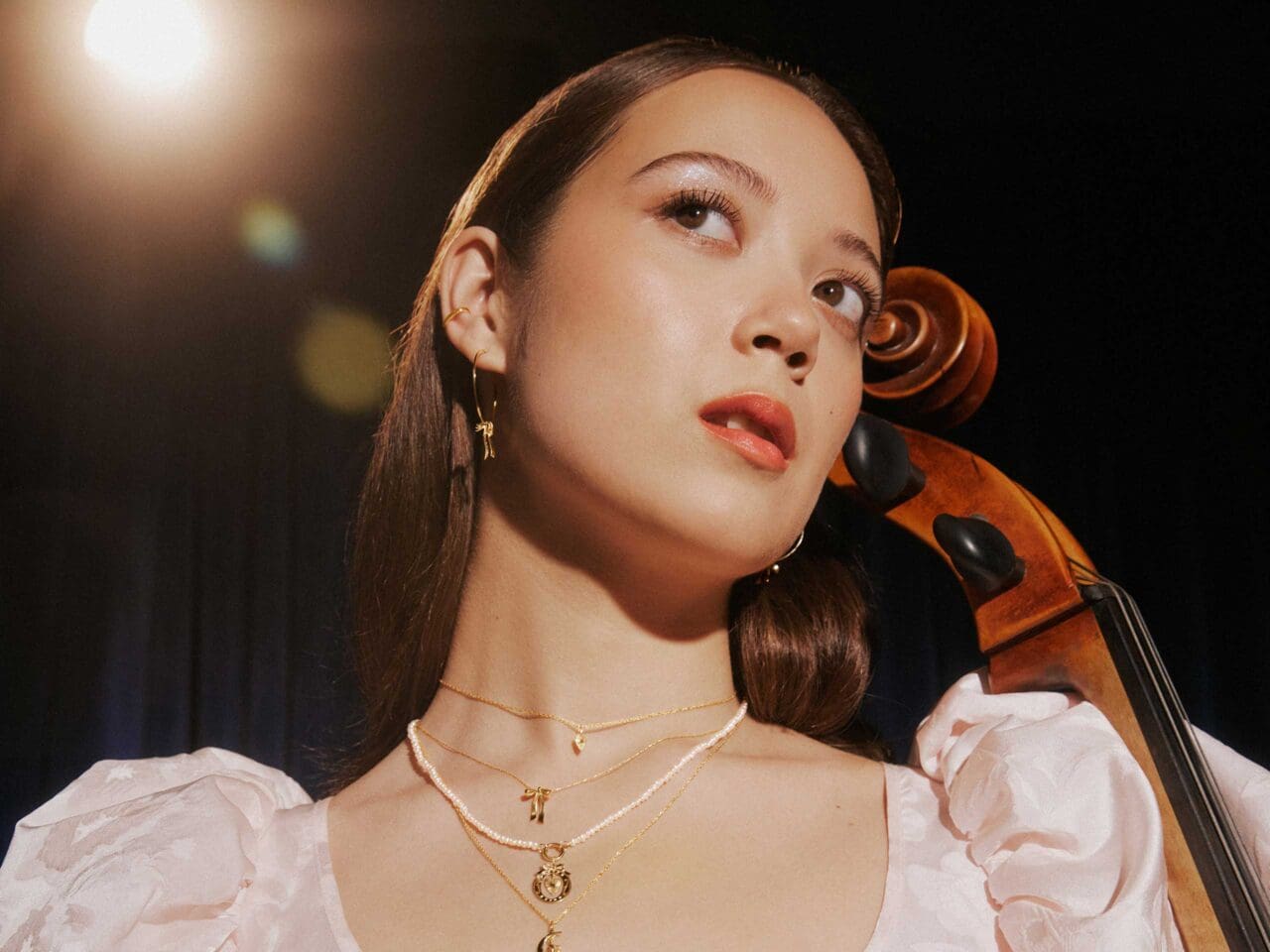 laufey with a violin wearing catbird jewelry