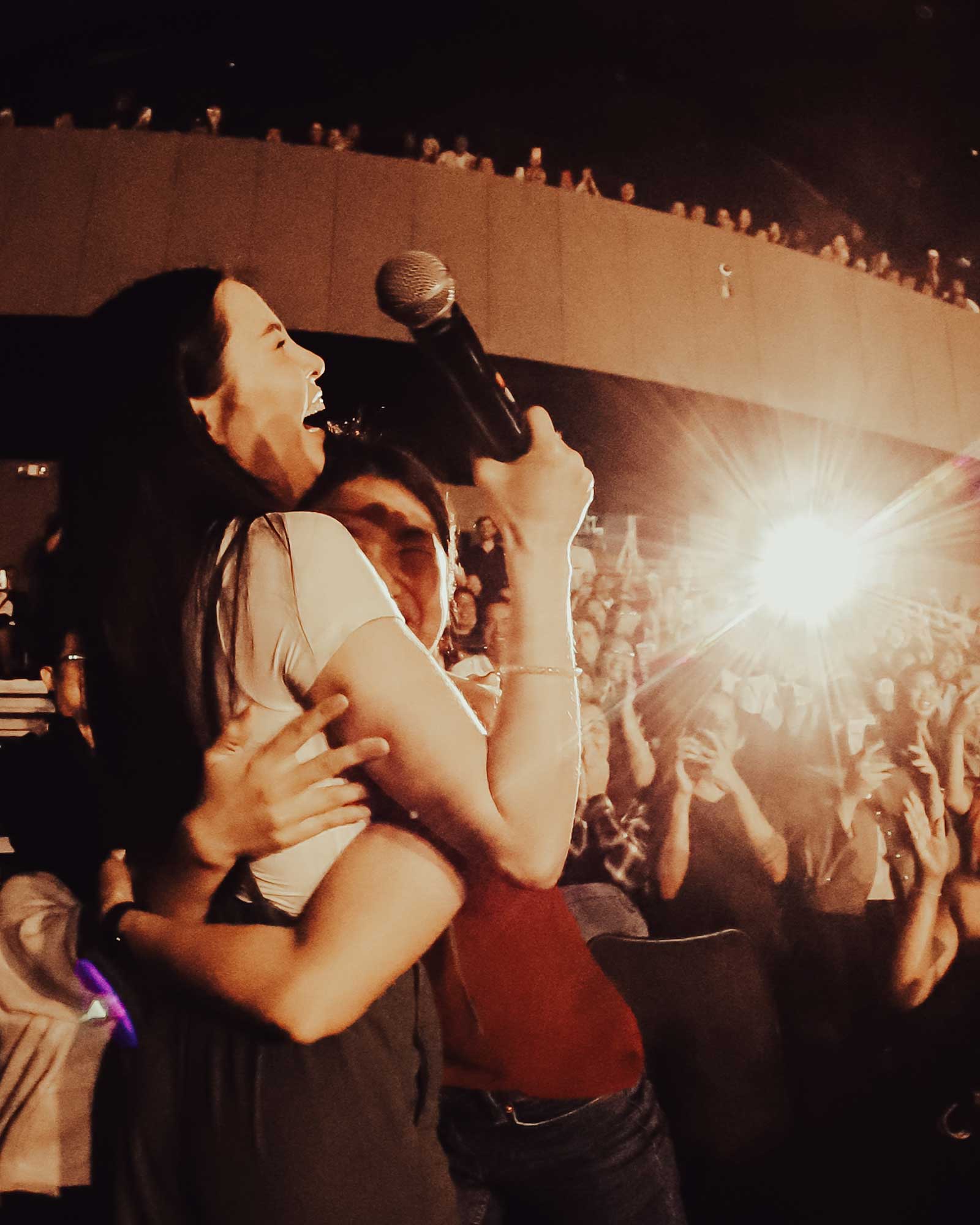 Anna Akana hugging an audience member at her sold-out show.