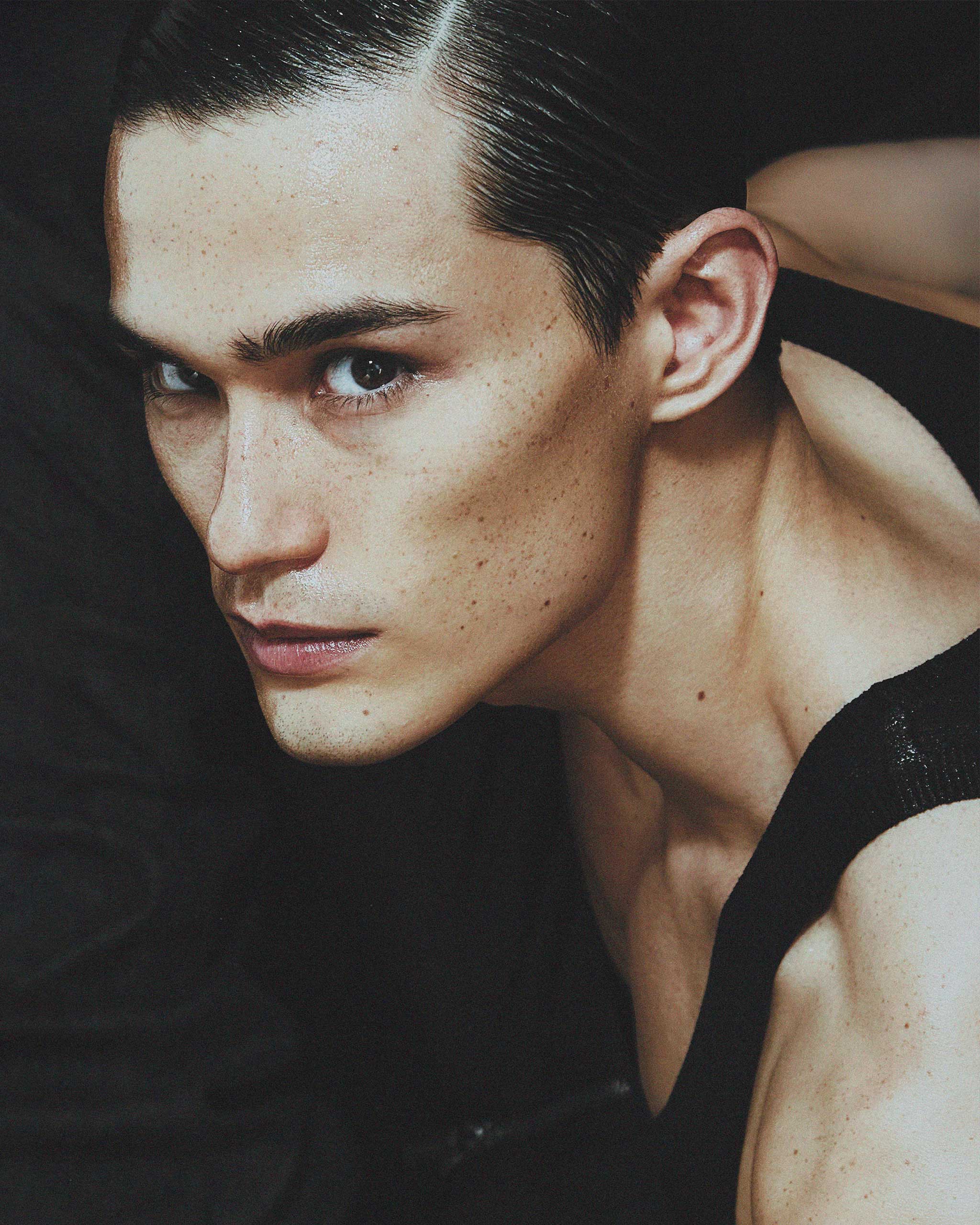 Side profile photograph of Alex Schlab wearing a black tank top.