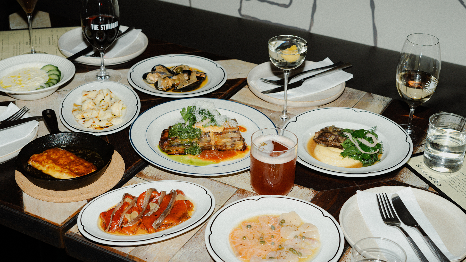A table covered in plates of food and drinks