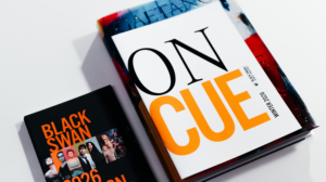 2026 On Cue magazine placed on a coffee table next to a 2026 Season brochure