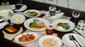 A table covered in plates of food and drinks