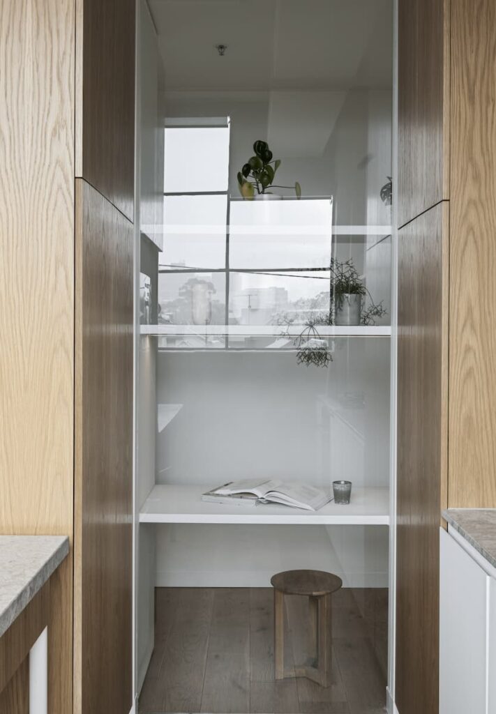 Oak flooring and joinery, grey limestone benchtops and white surfaces create a relaxed, simple and clean aesthetic in this small kitchen. | Designed by Melanie Beynon | Photography: Tom Blachford