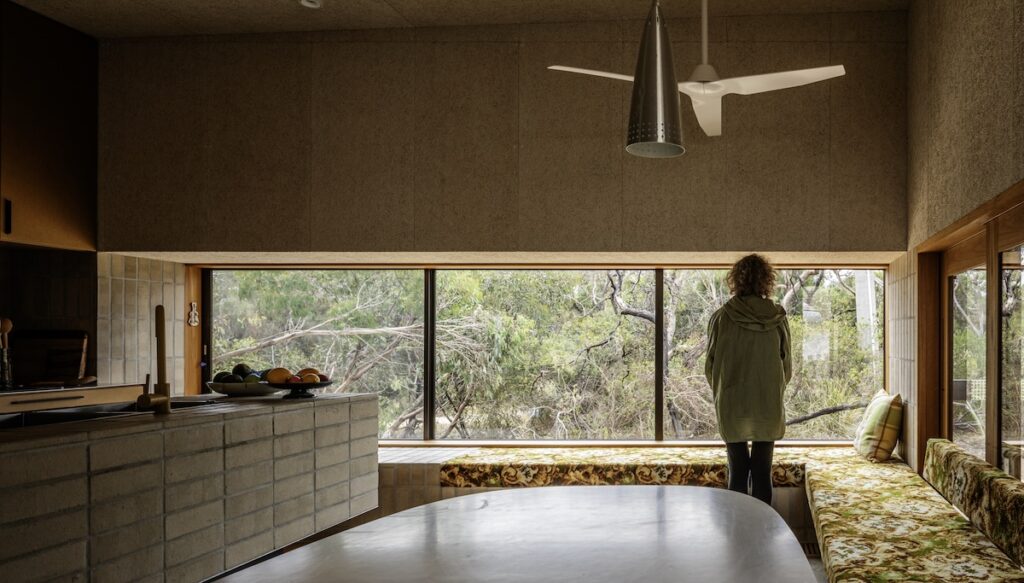 Kitchen window seat and long banquette looking to native vegetation beyond, photographed for green magazine issue 105: Timeless by Trevor Mein.