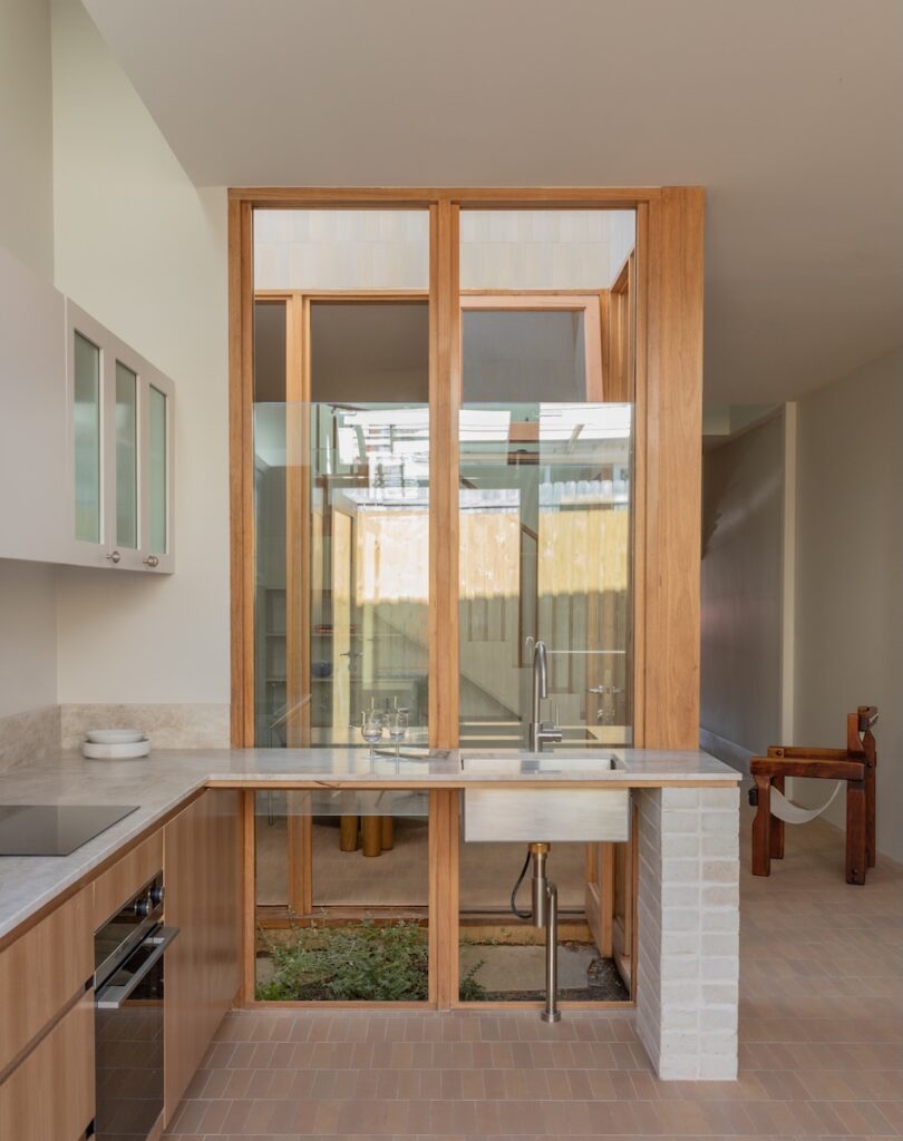 Open space beneath kitchen bench fostering visual connection to courtyard garden, photographed for green magazine issue 105: Southern Calm by Joanne Ly.