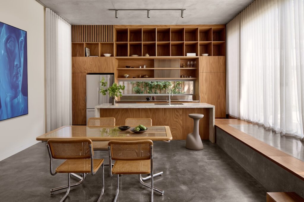 Rotary-cut blackbutt veneer cabinetry and tinted burnished concrete flooring, photographed for issue 106: Snuck In by Jack Lovel.