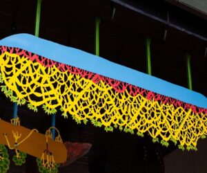 Hanging sculptural metalwork forms suspended beneath a timber ceiling at Barangaroo South.