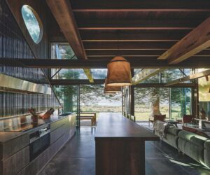 The kitchen forms the central zone, with a large island made from reclaimed teak acting as both bench and dining table, photographed for issue 107: Weather Withall by Zella Casey Brown.
