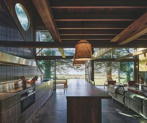 The kitchen forms the central zone, with a large island made from reclaimed teak acting as both bench and dining table, photographed for issue 107: Weather Withall by Zella Casey Brown.