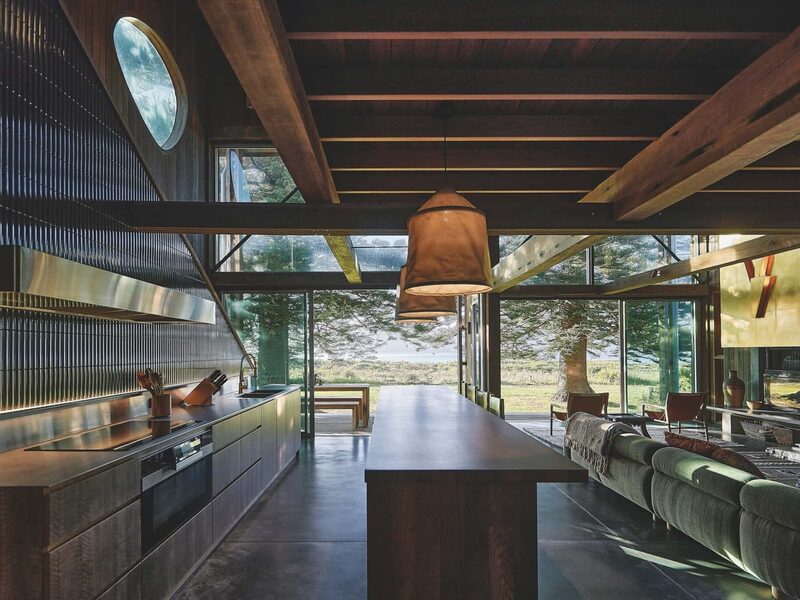 The kitchen forms the central zone, with a large island made from reclaimed teak acting as both bench and dining table, photographed for issue 107: Weather Withall by Zella Casey Brown.