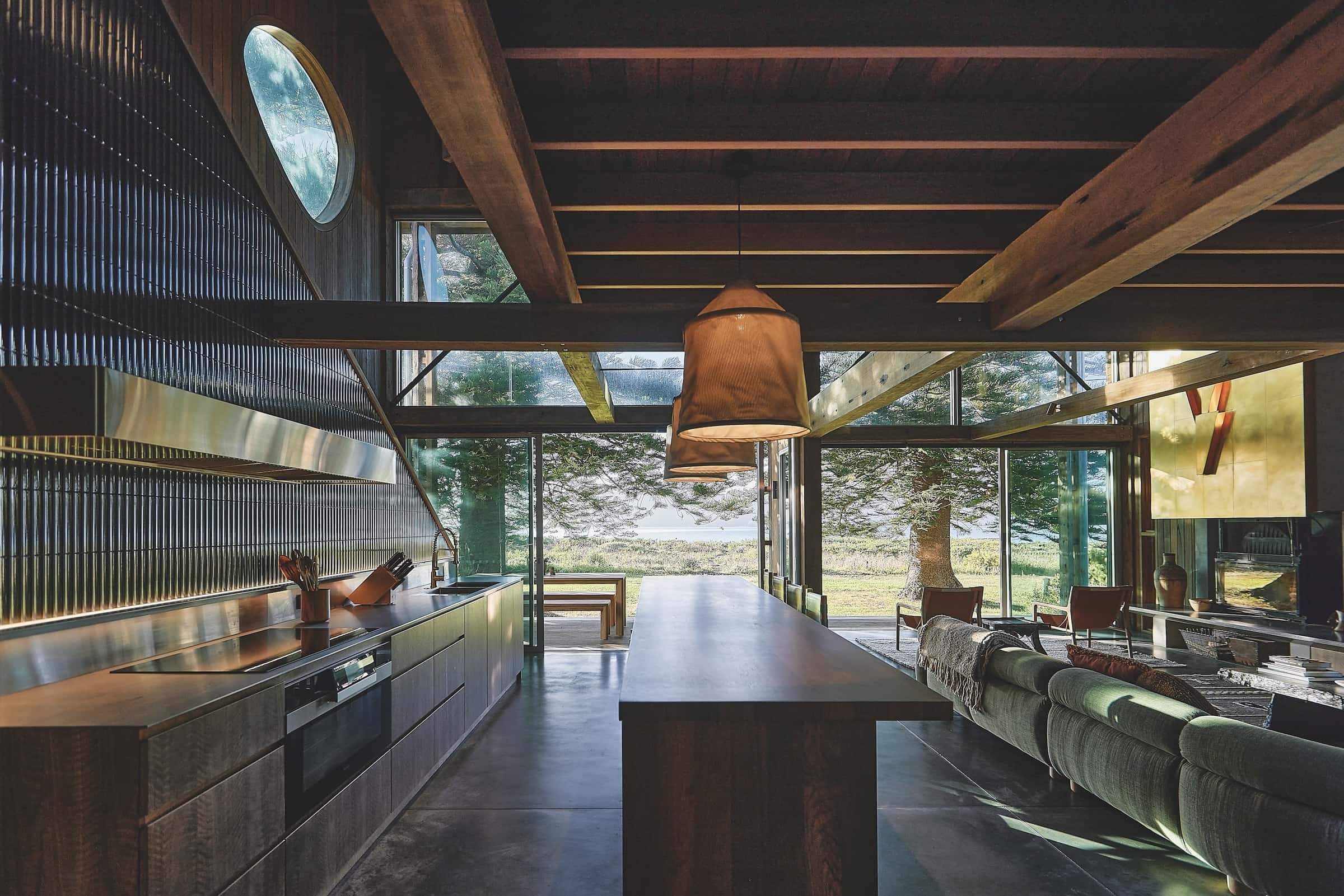 The kitchen forms the central zone, with a large island made from reclaimed teak acting as both bench and dining table, photographed for issue 107: Weather Withall by Zella Casey Brown.