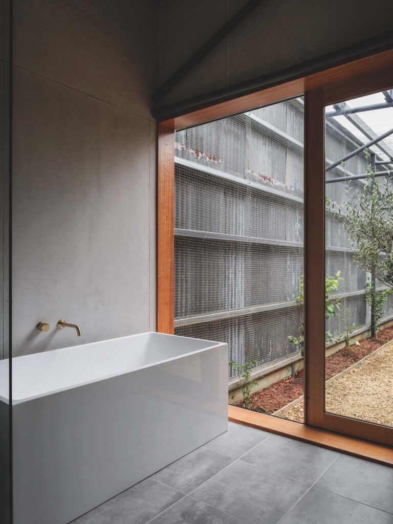 Bath with a view into the internal, planted courtyard, photographed for issue 107: Assemblage by Adam Gibson.