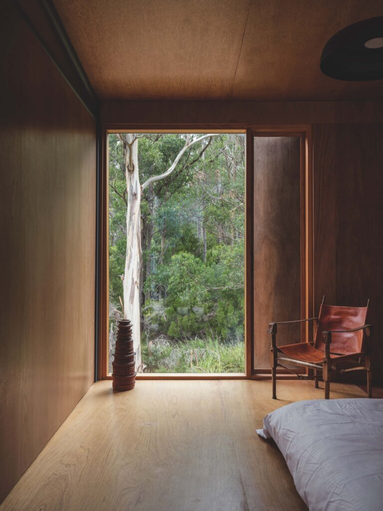 All of the minimally furnished bedrooms have a view of the Eucalyptus forest through room-height, screened and shuttered windows, photographed for issue 107: Assemblage by Adam Gibson.