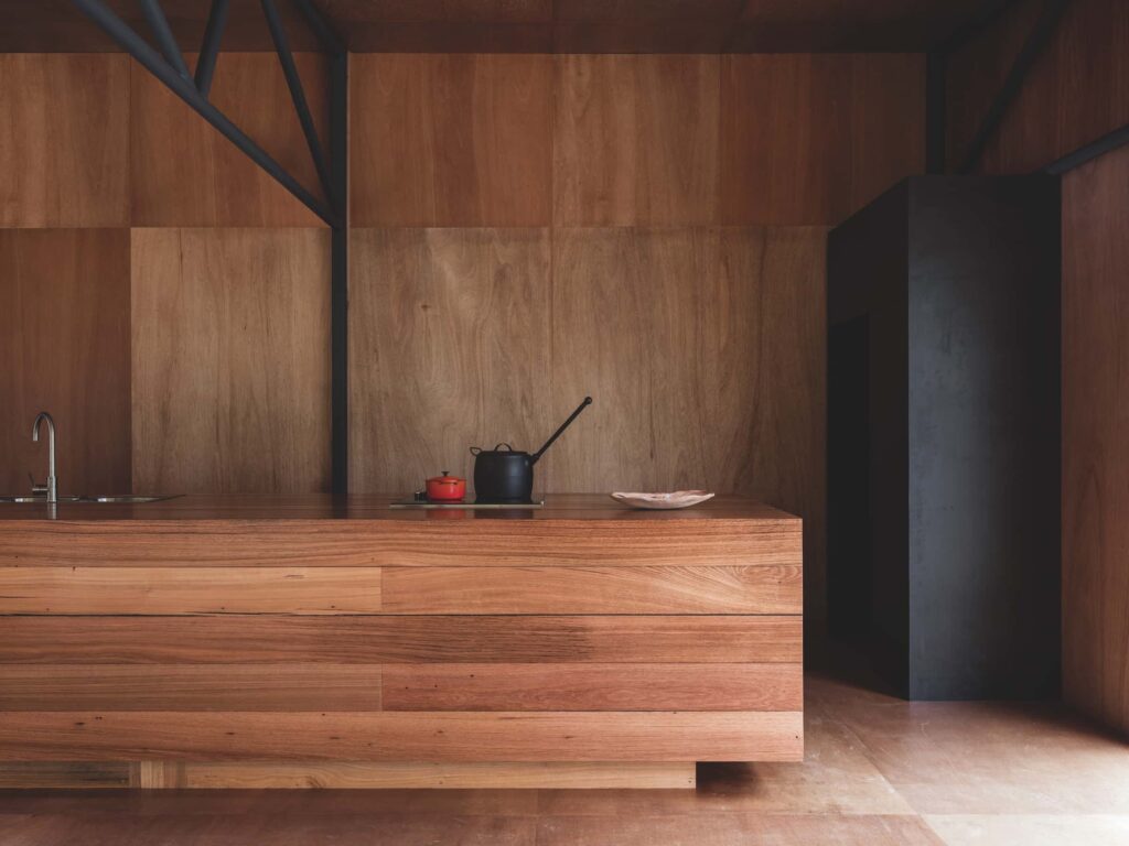 The kitchen’s central bench has a stovetop and oven, although most of the cooking is done on the deck’s woodstove, photographed for issue 107: Assemblage by Adam Gibson.