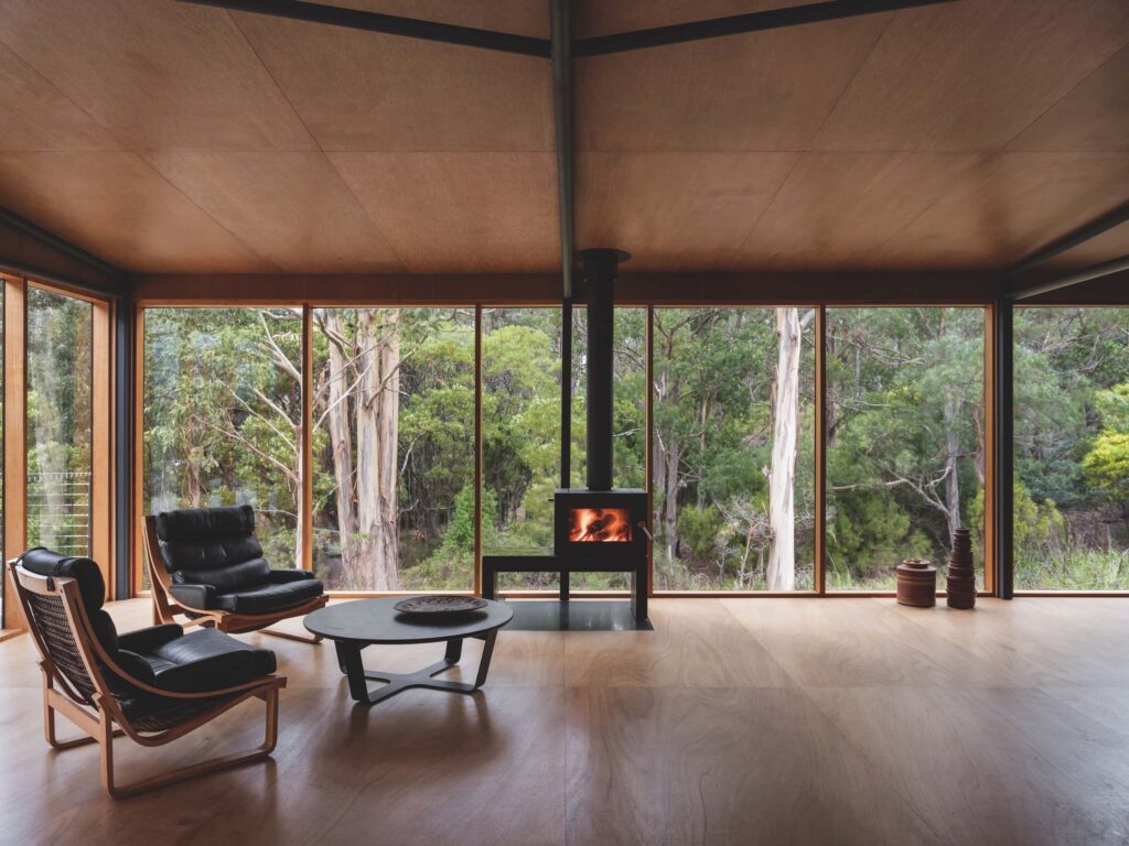 The living room opens on one side to the deck, but can be closed up and warmed with the wood stove in cooler weather, photographed for issue 107: Assemblage by Adam Gibson.