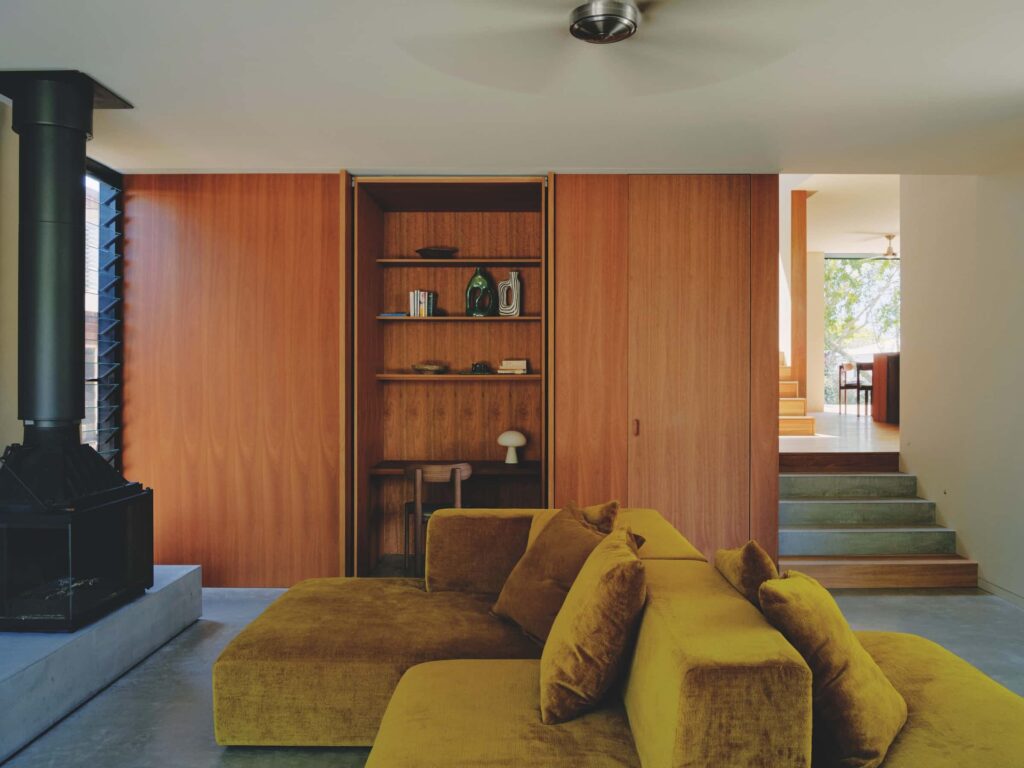 From the living room’s interior, views through the central staircase reveal the home’s split level connections, while operable glass louvres finely regulate light and ventilation, photographed for issue 107: A Coastal Compact by Tom Ross.