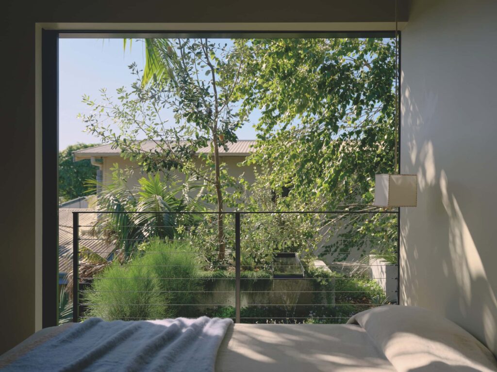 Enveloped by roof gardens, the main bedroom features a full height sliding opening with only a minimal balustrade dissolving the boundary between interior and landscape, photographed for issue 107: A Coastal Compact by Tom Ross.