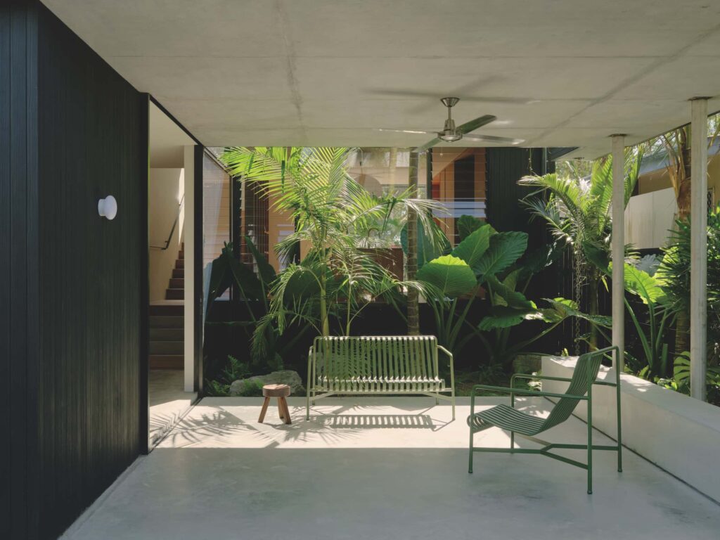 The covered courtyard and adjacent garden void illuminate the kitchen beyond, drawing natural light deep into the heart of the home, photographed for issue 107: A Coastal Compact by Tom Ross.