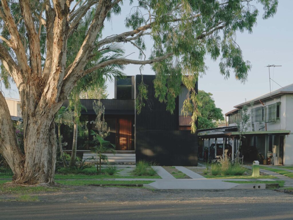 Tucked back from the street, Brunswick Heads House sits within a lush garden, its black timber façade sculpturally contrasting nearby weatherboard houses whilst harmonising with the street, photographed for issue 107: A Coastal Compact by Tom Ross.