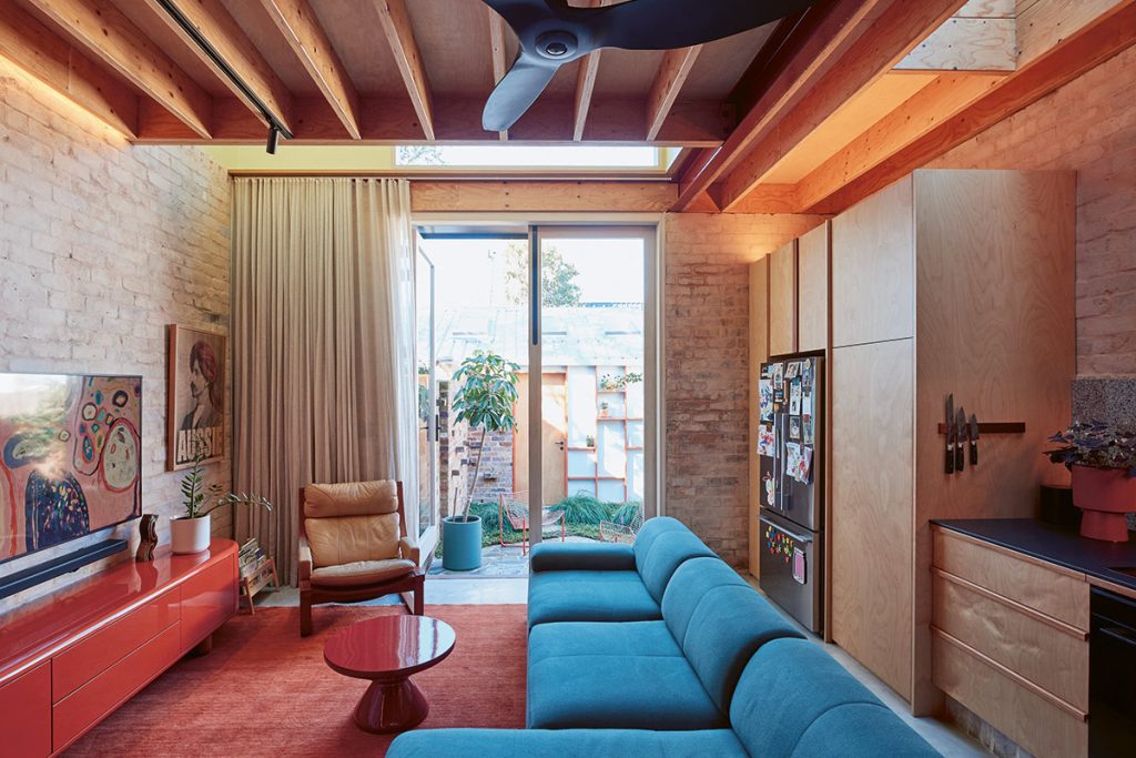 A double-height ceiling void, painted yellow, brings generosity and light to Hume and Tarr's relatively compact kitchen/living room. Photo: Andreas Bommert