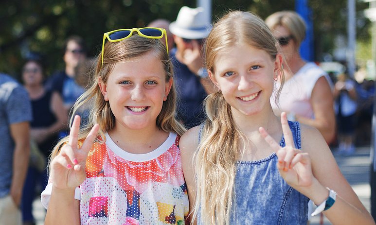Two young girls at Elizabeth Quay opening doing the peace symbol