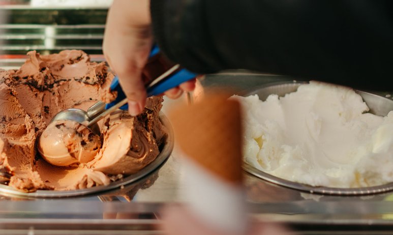 Someone scooping chocolate gelato
