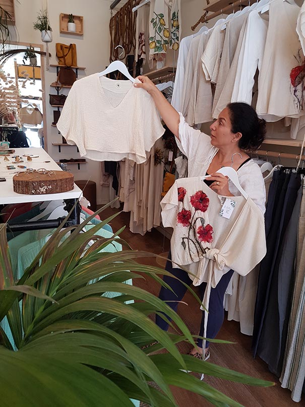 Woman holding up neutral coloured tops