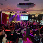 Ballroom full of people attending a fancy evening event