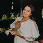 Female in white dress holding a clear glass award