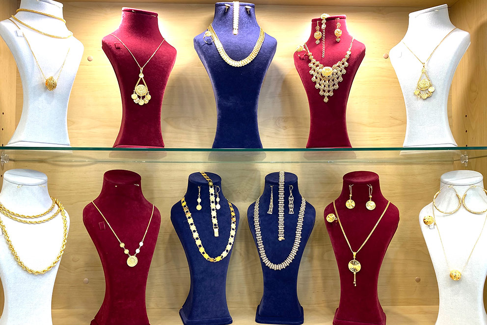 Rows of gold jewellery displayed on neck mannequins