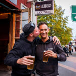 Two male friends embracing outside the Retreat Hotel on Sydney Road Brunswick