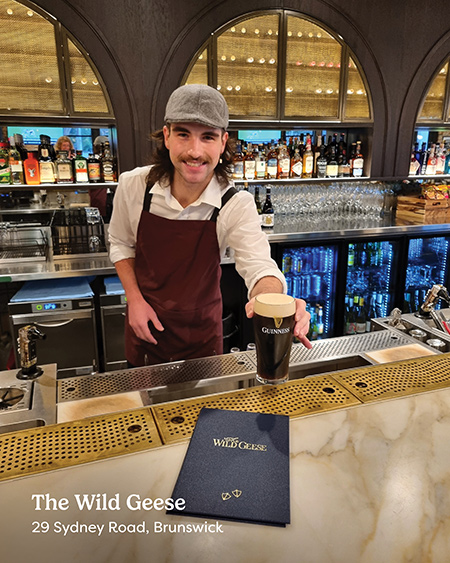 A young bartender offering a pint of Guinness at The Wild Geese on Sydney Road Brunswick.
