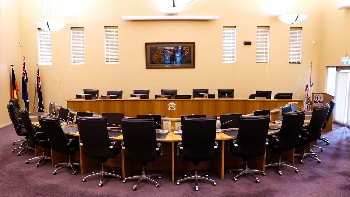 The Cessnock City Council Chambers with chairs behind the tables.