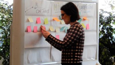 Image of participating putting up a sticky note containing their feedback on the draft Strategy