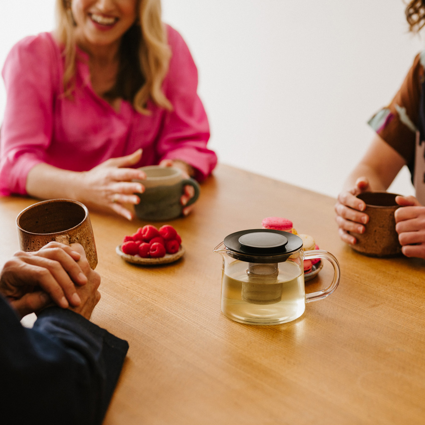Three team members from Inner Melbourne Clinical Psychology sit around a table, drinking tea