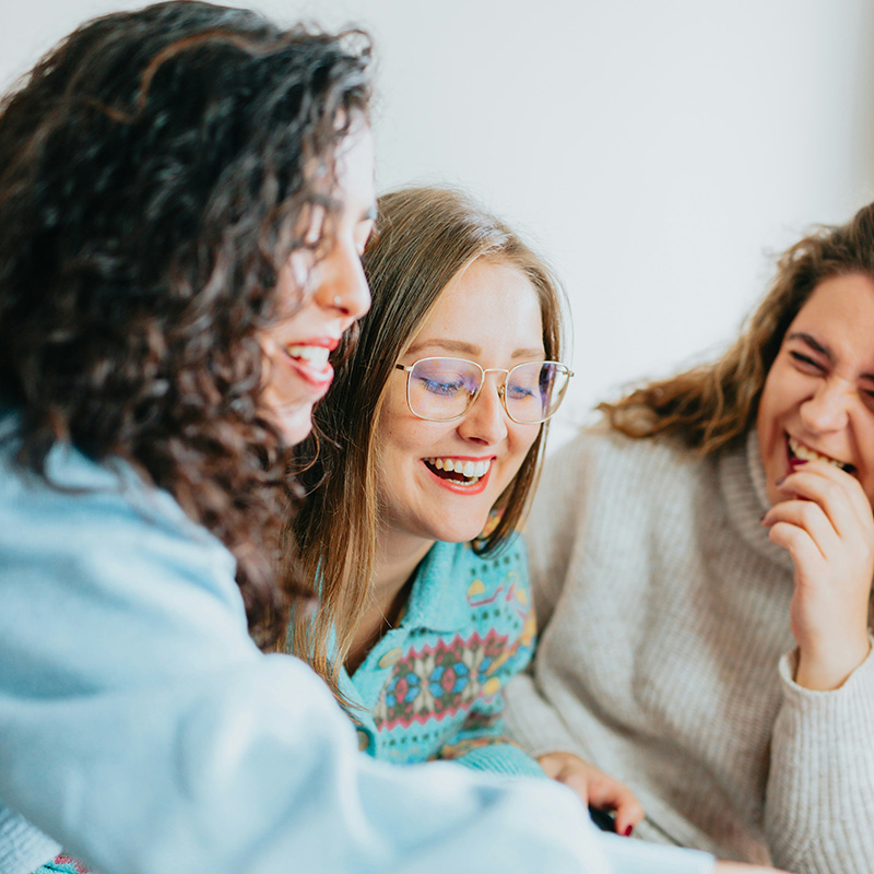 Three women sitting and laughing together